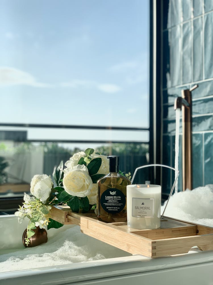 Wooden Bath Tray With Liquid Soap Scented Candle And Flowers On A Bathtub At The Albert Hotel