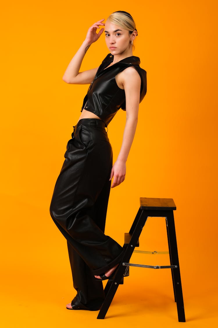 Woman In Black Leather Clothes Beside The Wooden Ladder