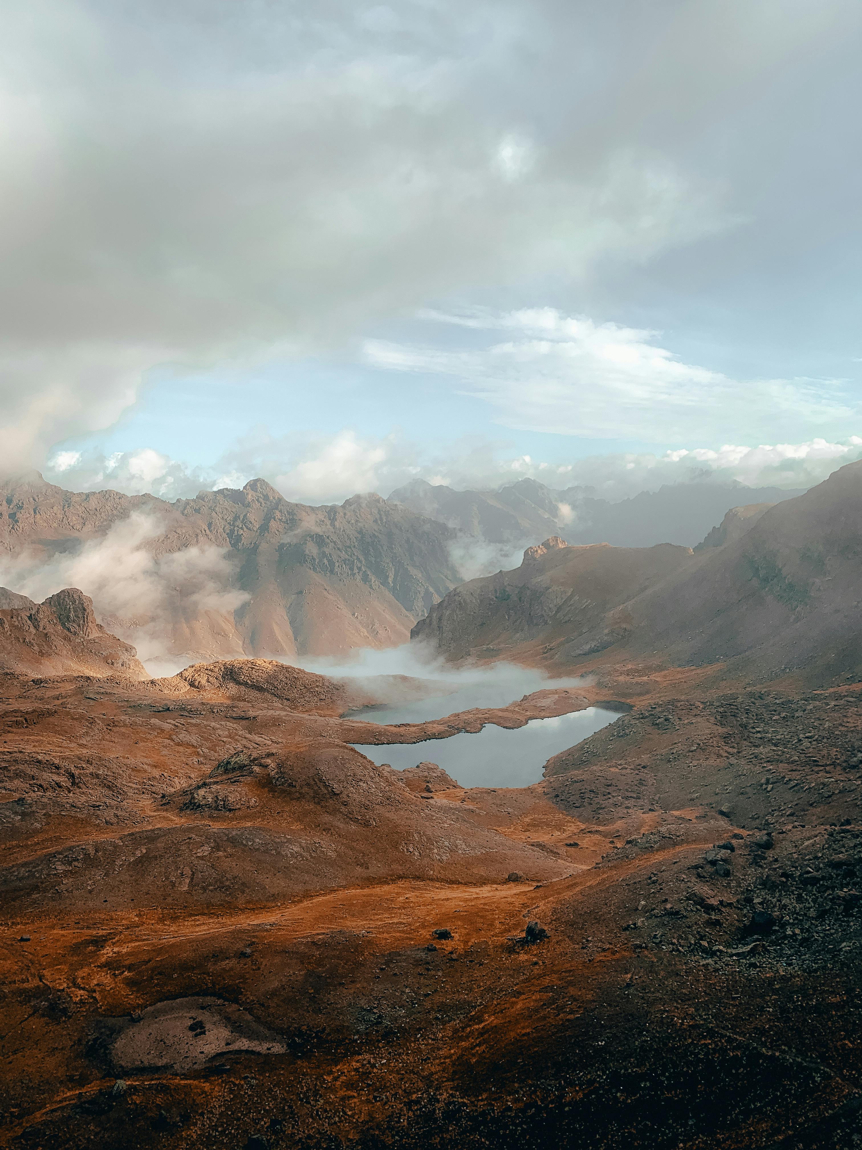 Stunning aerial view of Yedigöl Lake in Erzurum's misty mountains, showcasing natural beauty.
