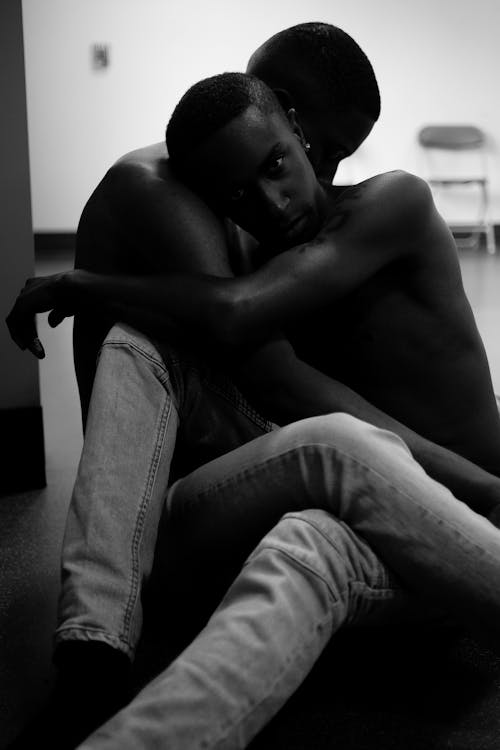 Grayscale Photo of Two Person Sitting on Floor