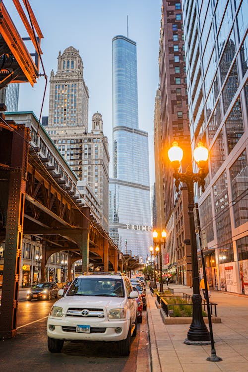 Cars Parked on Side of the Road in Between High Rise Buildings