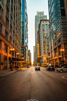 Vibrant urban street scene in downtown Chicago with towering skyscrapers at dusk.