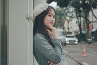 Woman in Gray Long Sleeve Shirt With White Flower on Her Ear