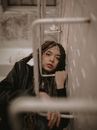 Girl with Dreadlocks Looking Through Fire Escape Ladder
