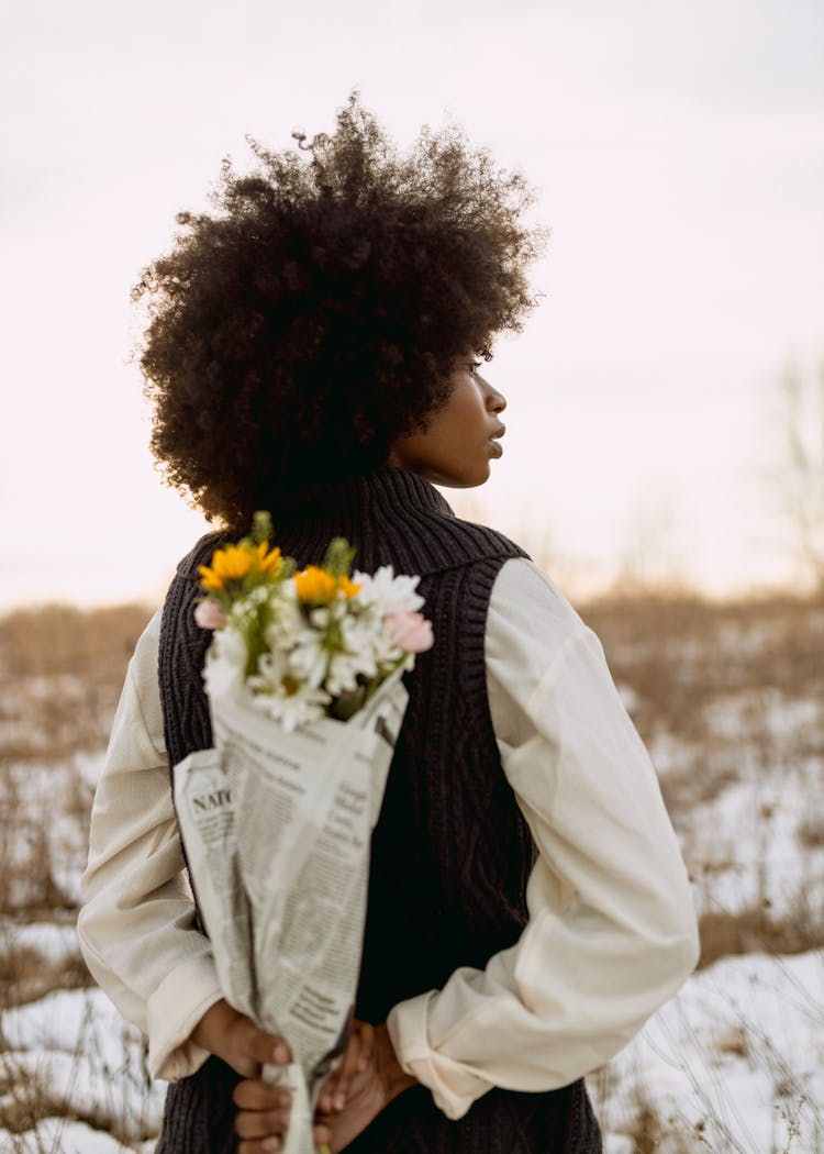 Woman Holding Bunch Of Flowers Behind Back 