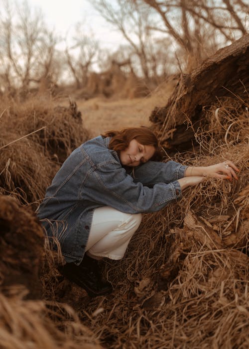 Young Woman Cuddled up in Grassy Ditch