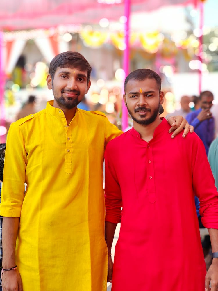 Man In Yellow Shirt Dress Standing Beside Man In Red Shirt Dress