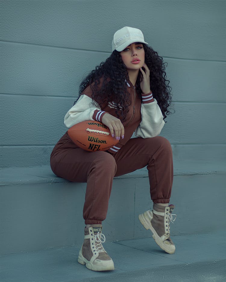 Woman In Baseball Hat Sitting Down