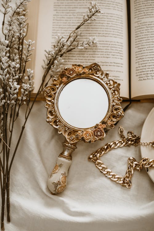 Free Mirror Lying on Open Book Stock Photo