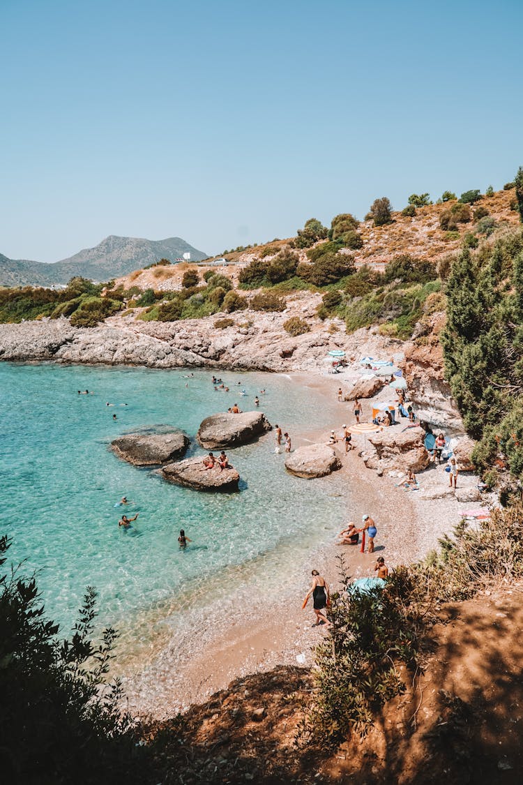 People Playing On Rocky Beach