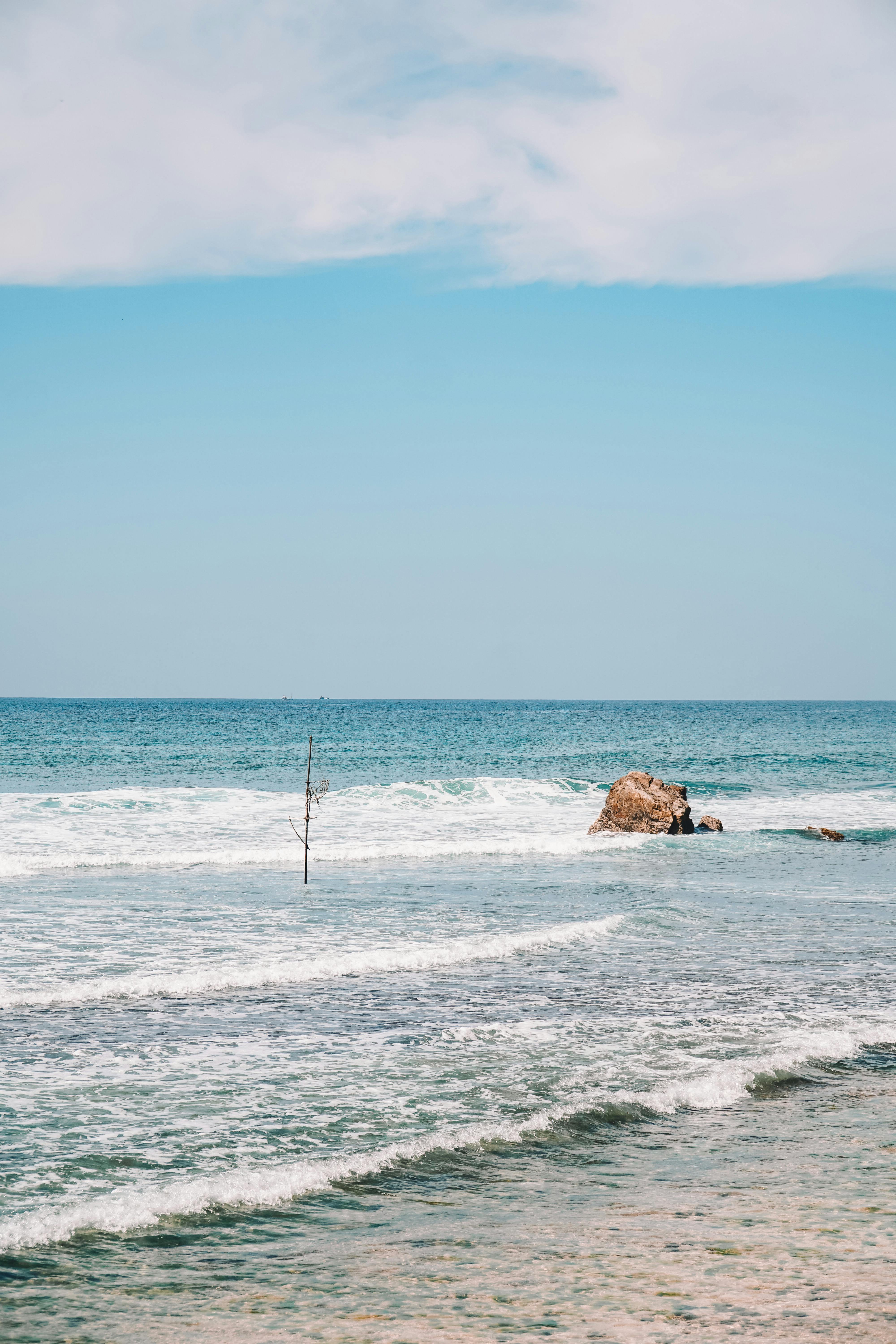 Tranquil beach view in Sri Lanka with gentle waves and clear sky.