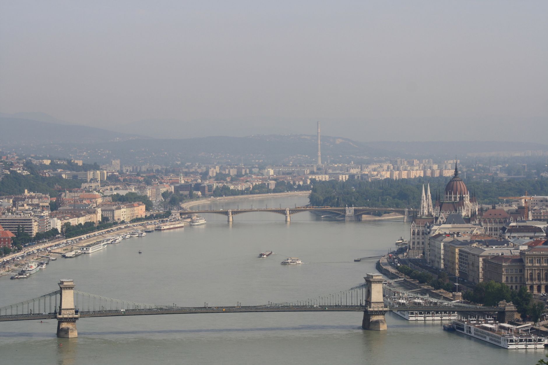 Stunning aerial view of Budapest featuring the Danube River and Chain Bridge under a clear sky.