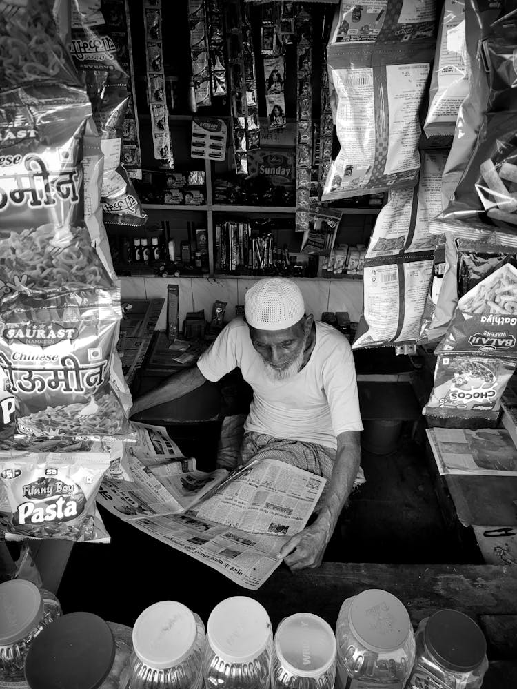 Elderly Thai Man Reading Newspaper In Store