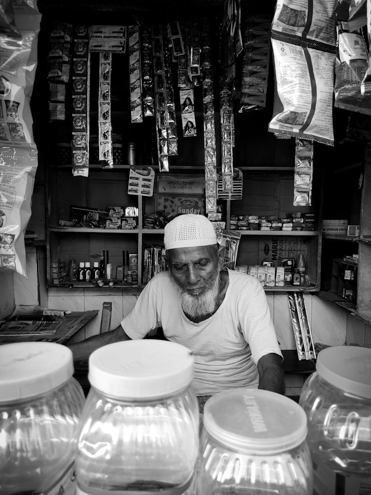 Elderly Thai Man Sitting Behind Counter At Store