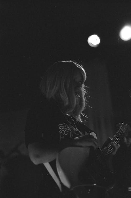Black and White Photo of a Woman Playing Electric Guitar