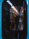 Man in Black Jacket Standing Beside Glass Window