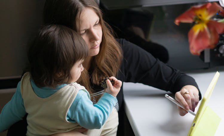 Mother Using An Apple Pencil To Write On An IPad 