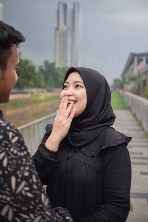 Woman in Black Hijab Looking at a Man