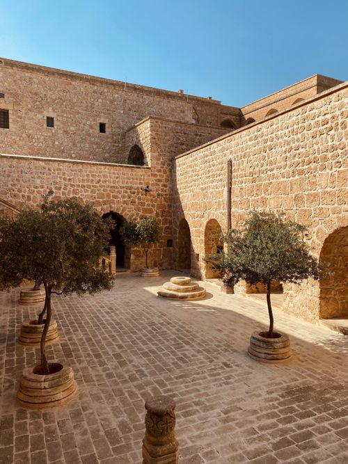 Free Discover the ancient stone architecture of Mor Gabriel Monastery's courtyard in Mardin, Turkey. Stock Photo