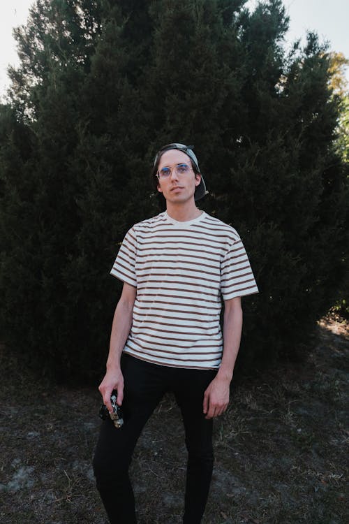 Man Standing in Front of Green Tree