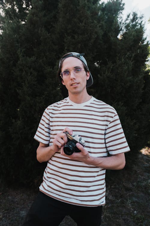 Free Man in Striped Shirt Holding a Camera Stock Photo