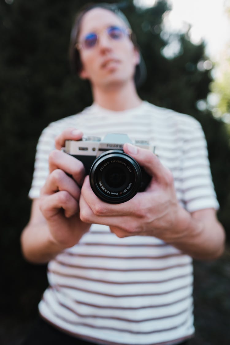 Person In White Strip Shirt Showing His Camera