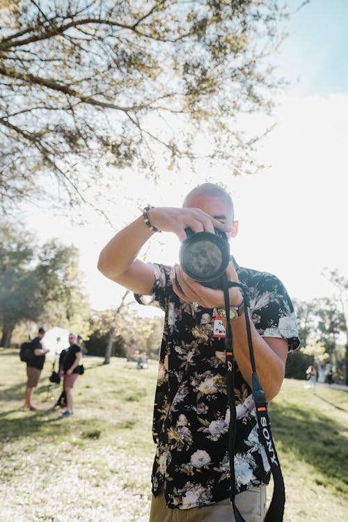 Man in Floral Shirt Taking a Photo