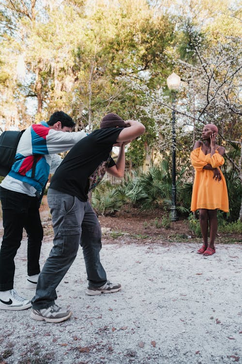 Photographers Taking Picture of a Woman Posing in Her Orange Dress