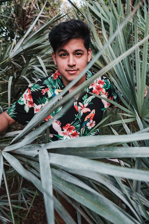 Young Man in Floral Shirt Among Yucca Leaves