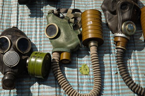 Free Collection of vintage gas masks placed on a patterned surface, highlighting safety and protection themes. Stock Photo