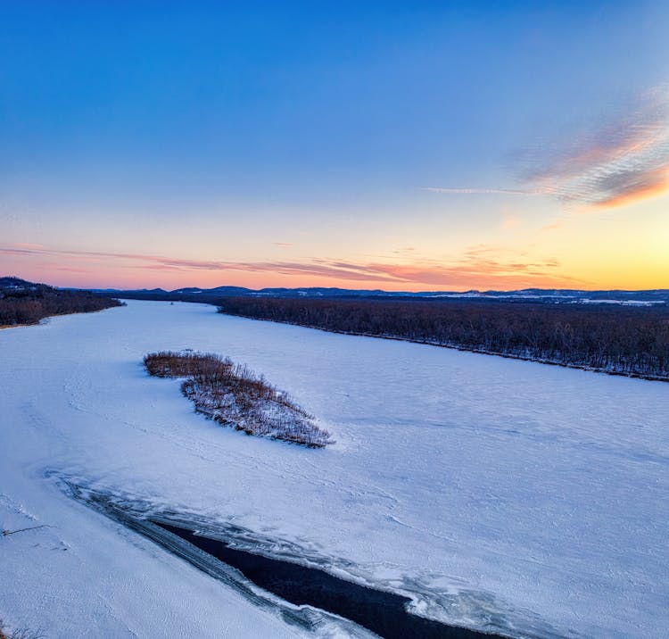 River Covered In Snow At Sunset 