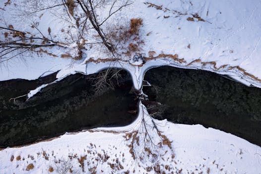Aerial drone shot of a winding river and snow-covered landscape in winter, Ella, Wisconsin.