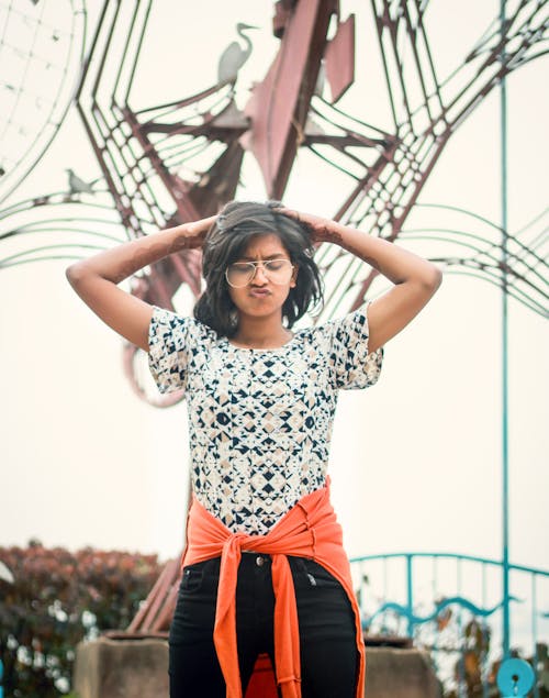 Free Women With Pouting Mouth Standing Near Brown Statue Stock Photo