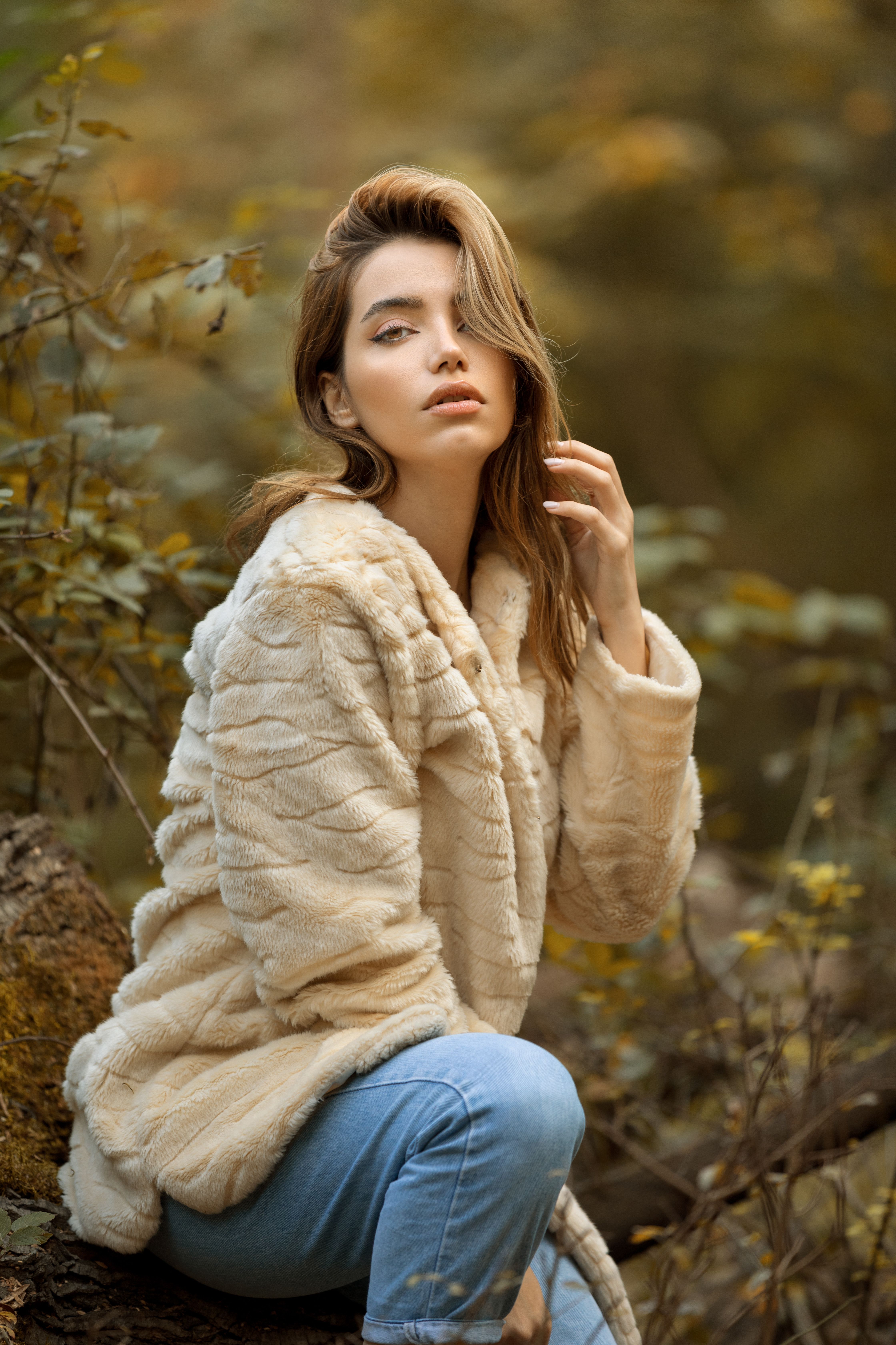 A Woman in Beige Sweater and Blue Denim Jeans · Free Stock Photo