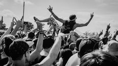 Grayscale Photo of People Raising Their Hands