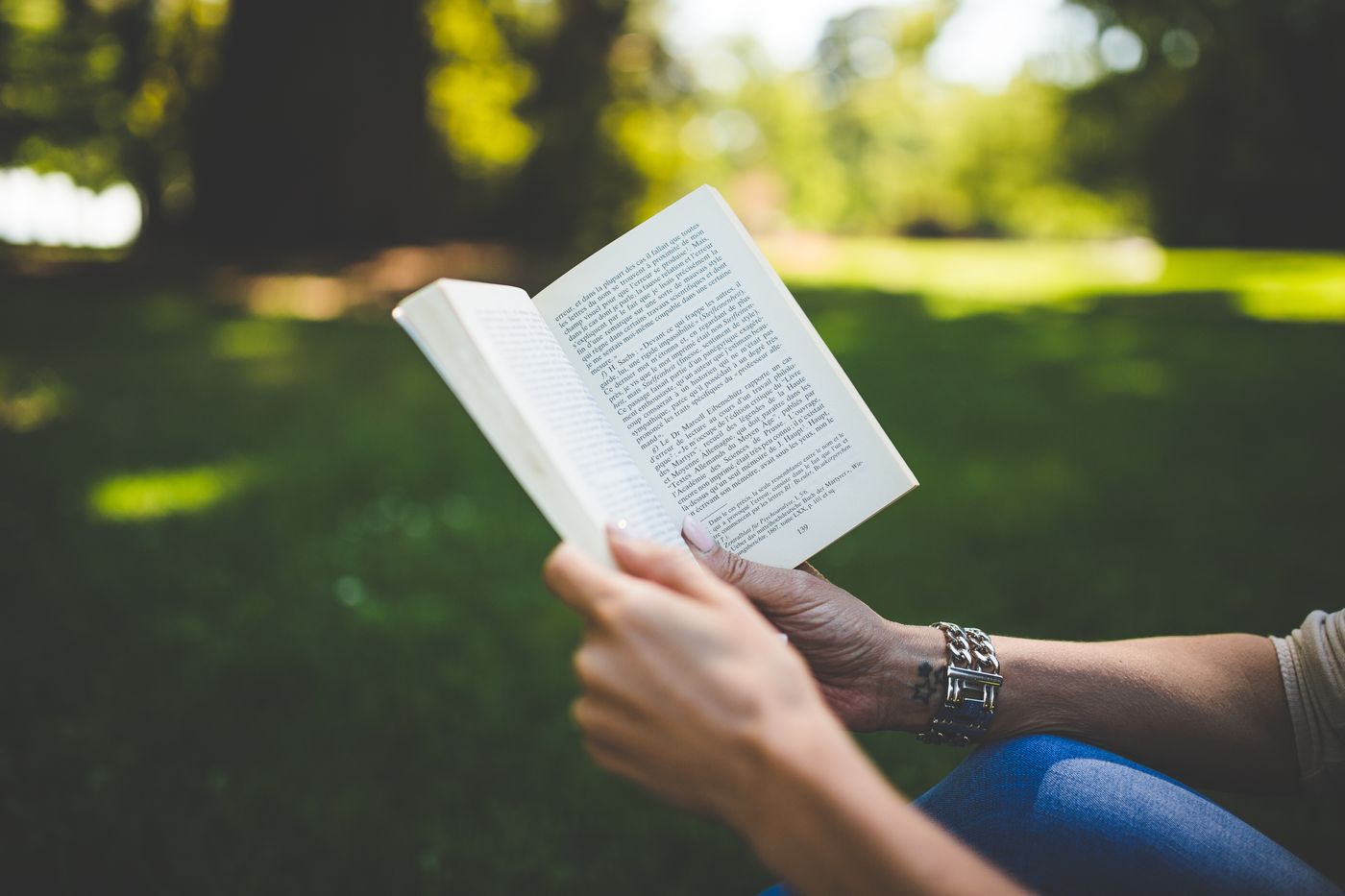 Person reading outdoors in a calm park setting