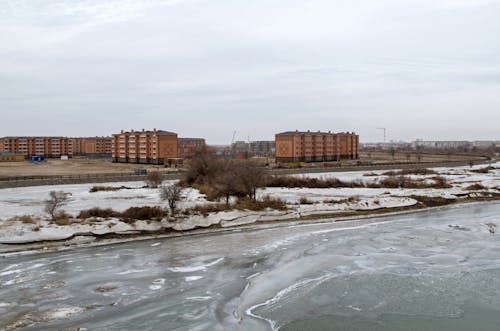 Aerial View of Urban Buildings Near a Frozen River 