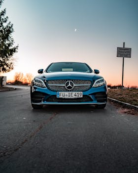 Front view of a luxury Mercedes-Benz parked on a road at sunrise, showcasing elegance and design.