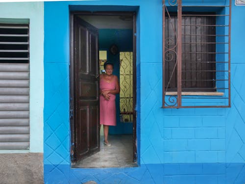 Woman in Pink Dress Standing Behind a Front Door