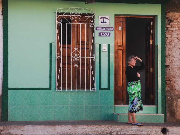 Woman Standing In Front Of An Open Front Door