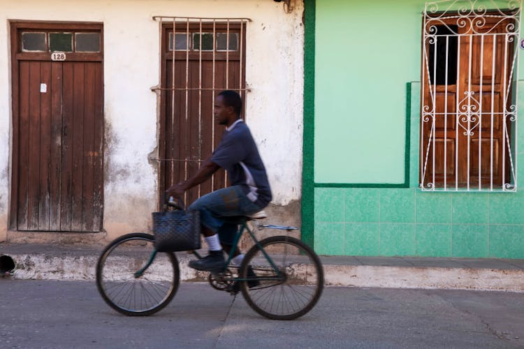 Man Riding Bicycle Along A City Street