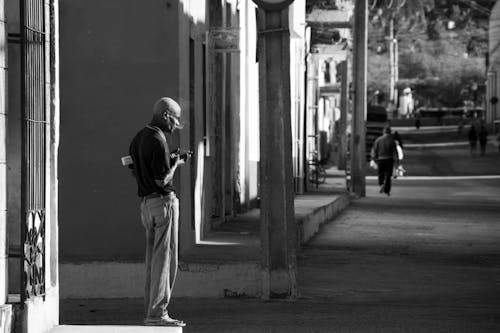Man Standing on Sidewalk