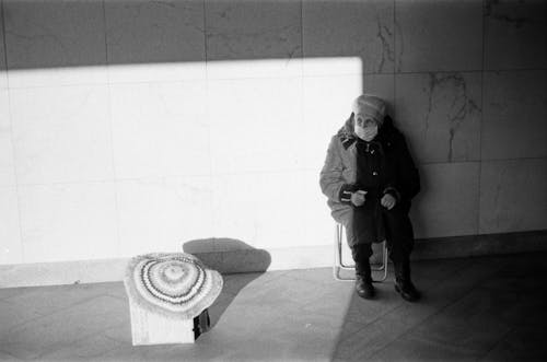 Senior Woman Sitting at Wall and Selling Handmade Rug