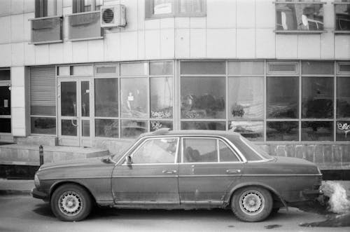 Car Parked near Building in Black and White