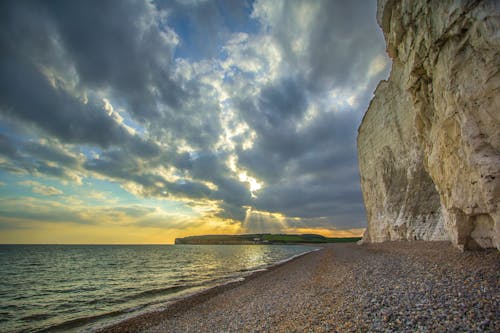 Photographie De Rocher Beige Et Gris Sur Le Bord De Mer