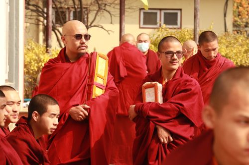 Free Group of Buddhist monks in traditional red robes gathered outdoors, capturing a serene moment. Stock Photo