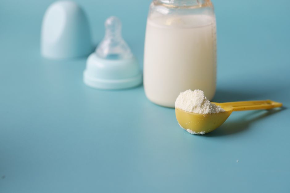 Infant formula powder in a scoop