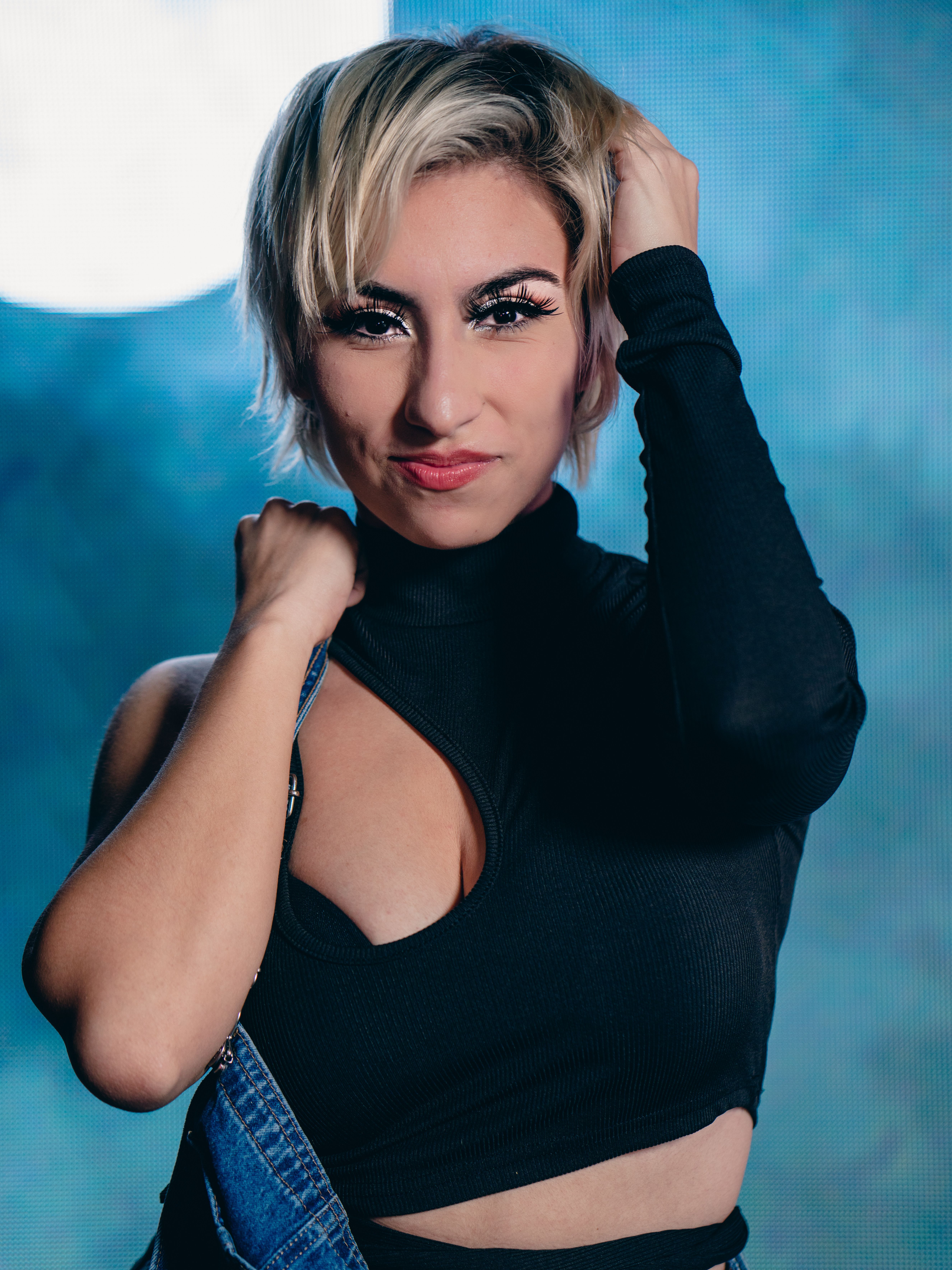 Stylish portrait of a woman striking a confident pose in a black top.