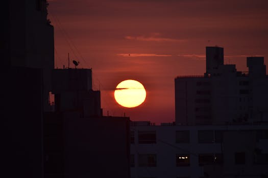 Silhouette of city buildings with a stunning sunset backdrop.