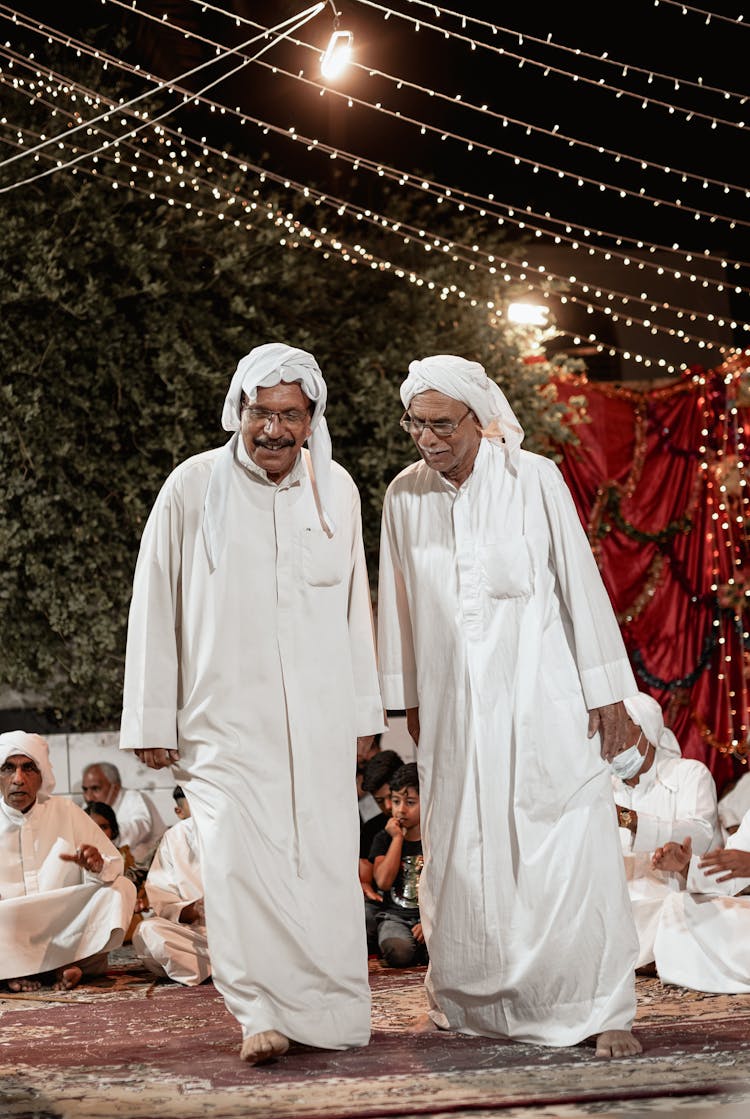 Senior Men In White Thobes Standing In A Ceremony Around People